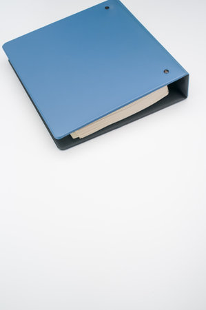 A vertical shot of a blue folder on a white surfaceの写真素材