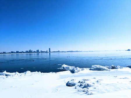 A snowy shore and a cityscape in the distanceの写真素材