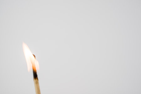 A closeup shot of a burning match isolated on a white backgroundの写真素材