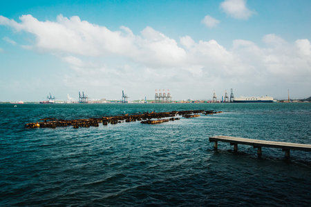 A beautiful seascape with an industrial port and cranes under a cloudy skyの写真素材