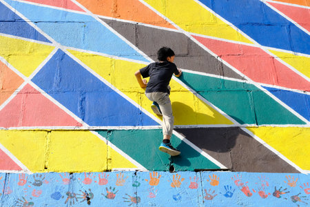 A young Malaysian boy running over a colorful street artの写真素材