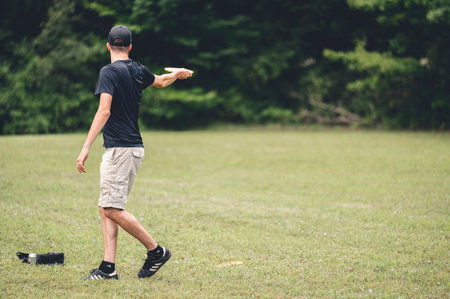 A young man playing disc golf in the fieldの写真素材