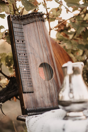 A vertical closeup of a brown zither on the table outdoors.の写真素材