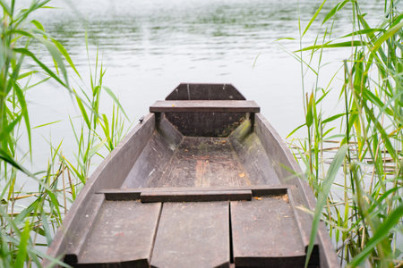 An old boat moored in the rushes on the Karsinskie Lake in the city of Swornegacie in Kashubiaの写真素材