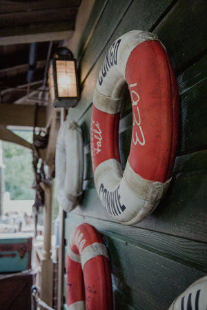 A view of lifebuoys attached to the wooden wall near the port on a sunny dayの写真素材