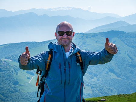 Happy Man Hike on top of the Monte Baldo with the Lake Garda at the backgroundの写真素材