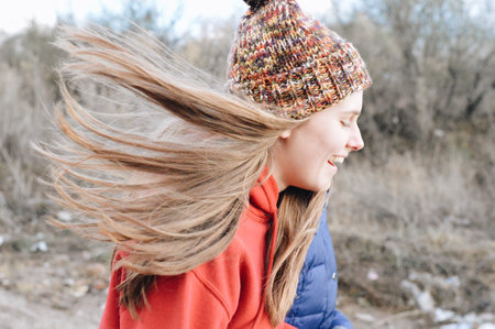 A young female in a hat with hair blowing from the windの写真素材