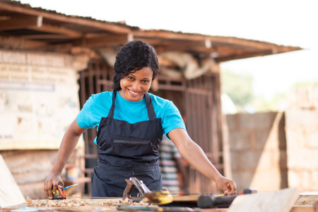 A closeup shot of a beautiful African carpenter female in her workshopの写真素材