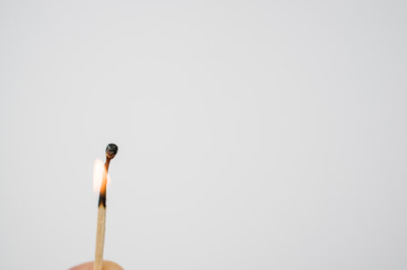 A closeup shot of a burning match isolated on a white backgroundの写真素材