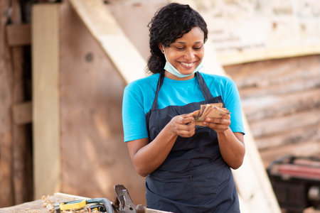 A closeup shot of a beautiful African carpenter female in her workshopの写真素材