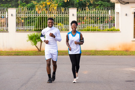 A young fit African couple running outdoors togetherの写真素材