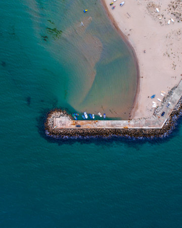 A bird's eye view of a blue beach with a peninsulaの写真素材