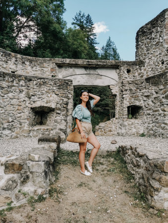 Front view of stylish young woman in front of old outpost ruin in Vuzenica, Slovenia.の写真素材