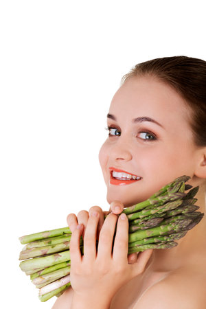 A portrait of a young happy female holding asparagus on a white backgroundの写真素材