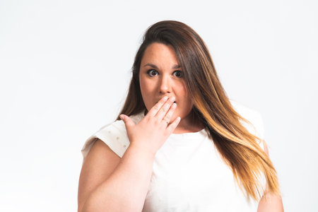 A beautiful attractive overweight female Caucasian model with a surprised face posing for a photoshootの写真素材