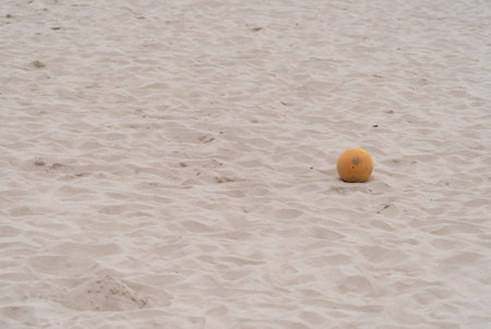 A small yellow ball on the sand at a beachの写真素材