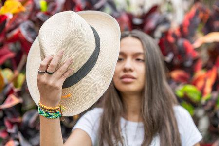 A young girl holding a summer straw hatの写真素材