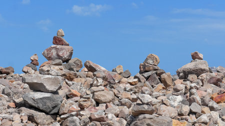 A closeup shot of stacks of stones with a blue sky on the backgroundの写真素材