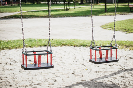 A selective focus of two swings in a playground during a sunny day