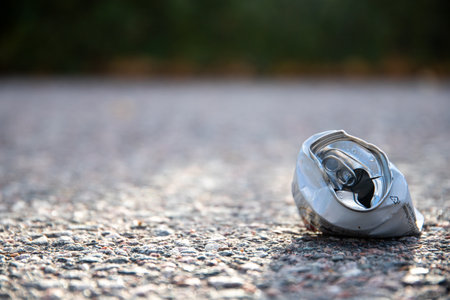 A selective focus shot of a crushed aluminum drink can on the street