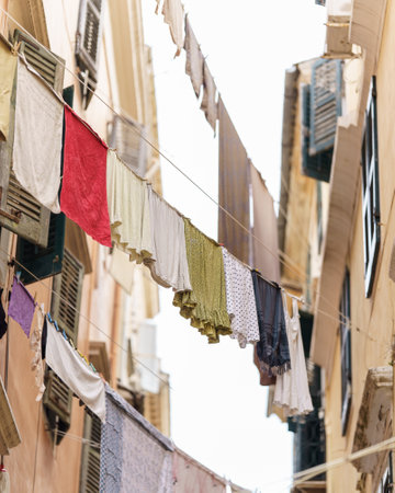 A vertical shot of clothes drying on ropes outdoors in the daylight with a blurry backgroundの写真素材