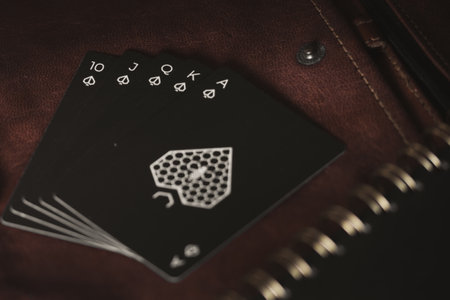 A closeup shot of a royal flush poker and blackjack cards against a brown surface