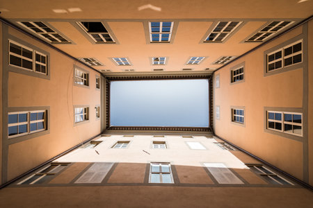 A low-angle symmetrical view from the center of the tall buildingsの写真素材