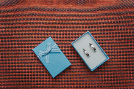 A top view of the silver precious engagement rings in the box on the brown surfaceの写真素材