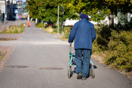 An old woman walking with a walker