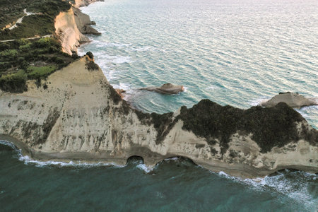 A landscape of cliffs with natural arches surrounded by the sea on a sunny day