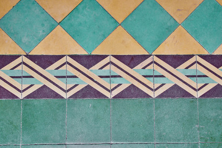 The decorative tiles with yellow and light blue-green colors with purple forming a pattern.