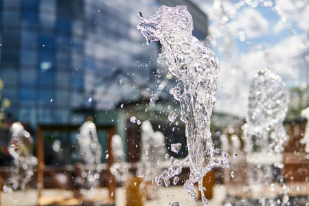 A selective closeup of water splashes of a fountain in a cit