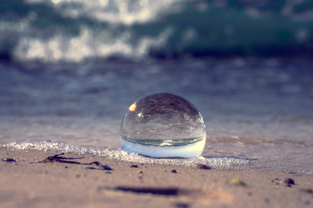 A crystal ball with the reflection on the sandy beachの写真素材