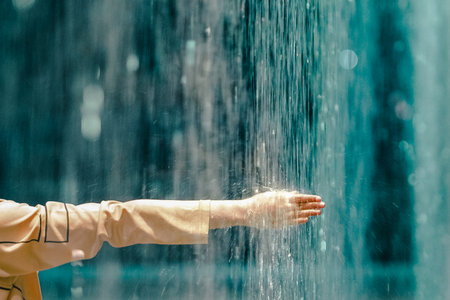 The arm of a person under the water pressure of a fountainの写真素材