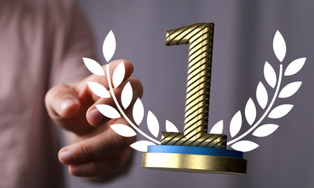 A 3D rendering of a first place golden award and male hand holding on a blurry backgroundの写真素材