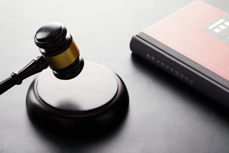 A wooden judge hammer with a book on the table