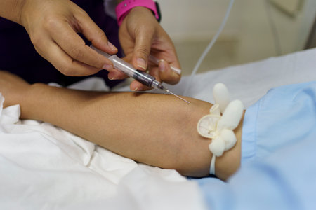 A nurse hand taking blood from the vein of a patient