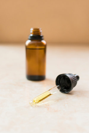 A vertical shot of a container filled with CBD oil on a tableの写真素材