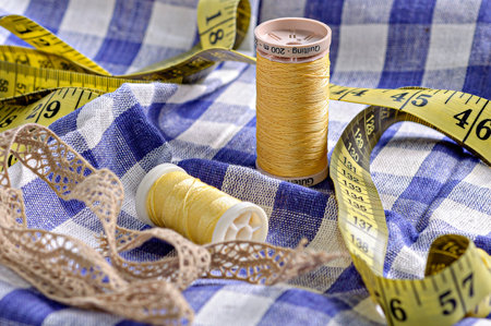 A closeup shot of yellow threads and measure tape on the clothの写真素材
