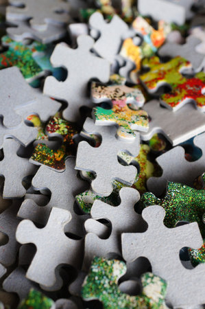A pile of puzzle pieces on the tableの写真素材