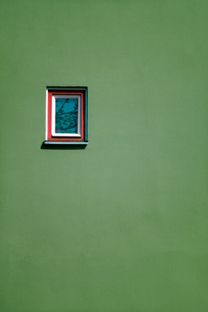 A vertical shot of a window on a green wall, building exteriorの写真素材