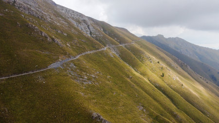 An aerial view of an empty narrow mountainside roadの写真素材