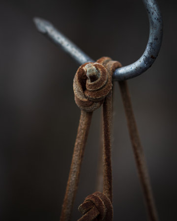 A vertical closeup shot of a tied rope with a hook on a blurred backgroundの写真素材