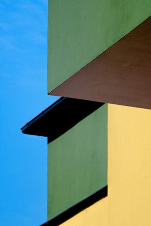 A vertical shot of the sharp angles of a building, yellow and green colored wallsの写真素材