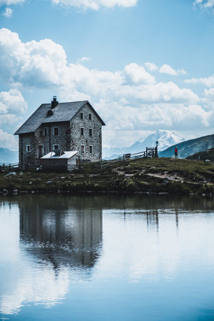 A vertical shot of a house near a lake under the cloudy skiesの写真素材