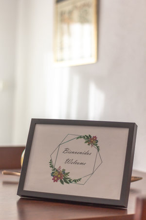A vertical shot of a welcome card in a frame on a tableの写真素材