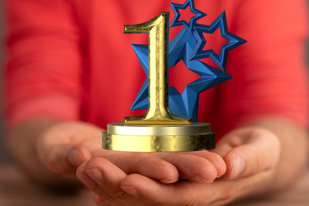 A man's hands showing a 3D rendered gold 1st place, winner's prizeの写真素材