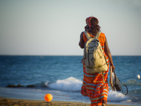 A black female walking along the beach on a sunny morningの写真素材