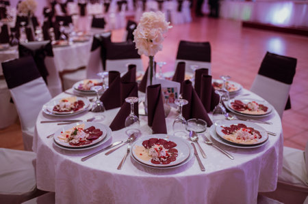 A scenic view of a wedding hall with decorated chairs and tablesの写真素材