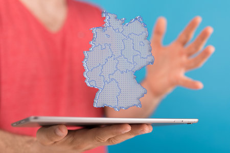 A person presenting a virtual 3D rendered projection of a hologram of the map of Germanyの写真素材
